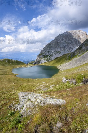 Mountain hut Obstanserseehuette at the mountain lake Obstansersee, behind rocky mountain peak