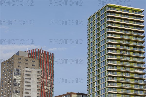 Modern skyscrapers with red and green elements, clear sky, skyline of a modern city on the river