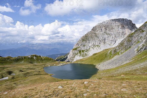 Mountain hut Obstanserseehuette at the mountain lake Obstansersee, behind rocky mountain peak