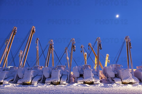 Cranes and equipment for oil production in the snow, twilight, Deadhorse, Alaska, USA, North
