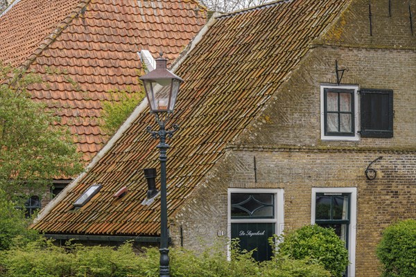 Quiet village street with characteristic brick houses and nostalgic street lamp, old houses with