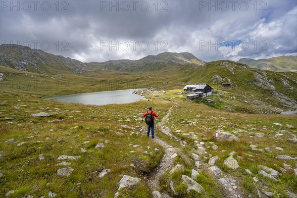 Mountaineer on a hiking trail to the mountain hut Obstanserseehuette at the mountain lake