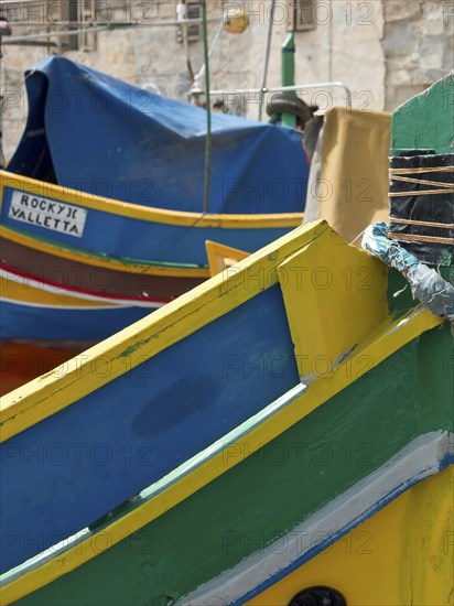 Colourful painted fishing boats in a mediterranean harbour area with name sign 'ROCKY JOE