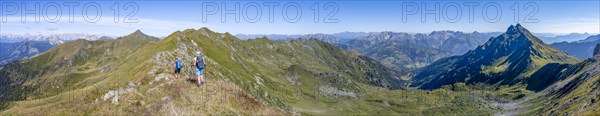 Panorama, mountaineer on a grassy ridge, view of the Lesach Valley and mountain panorama, Carnic