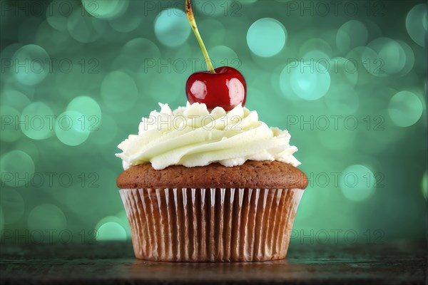 Cupcake with a swirl of vanilla frosting atop a delicate cherry against green background, AI