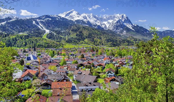 View of the village in spring with the Partenkirchen parish church in front of the Zugspitze group
