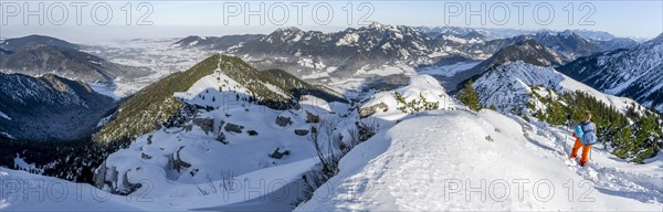 Hiker in winter climbing the Aiplspitz, winter, Alpine panorama with Aiplspitz, Schliersee and