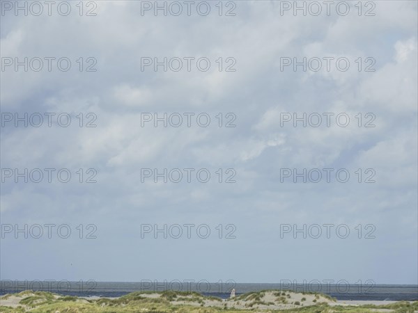 Lonely coastal area with cloudy sky and sea view, lonely beach with dune grass in the neighbouring
