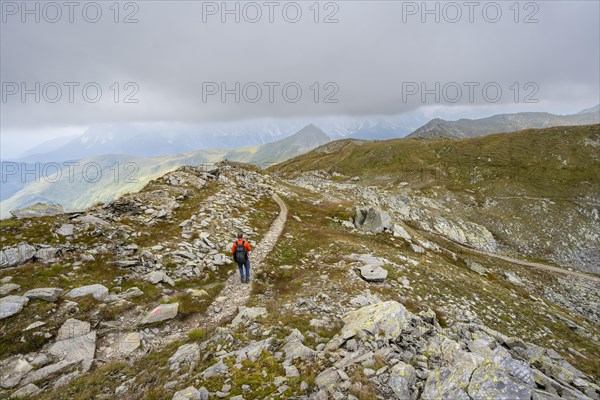 Mountaineers on a hiking trail descending to the Obstanserseehuette, Carnic Main Ridge, Carnic High
