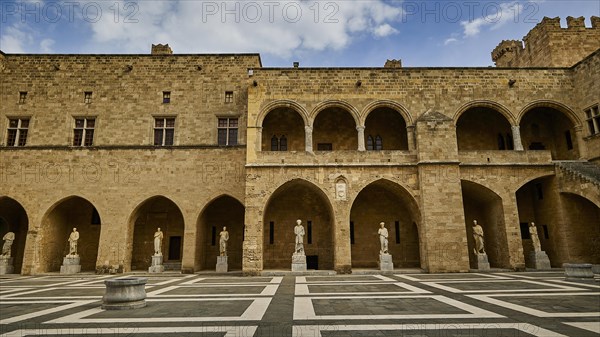Super wide angle shot, castle courtyard with arcades, statues and a chequered floor under a cloudy