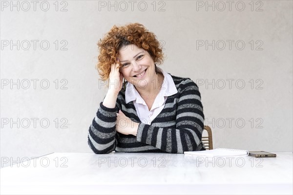 Portrait of a beautiful mid-adult redhead woman looking at the camera