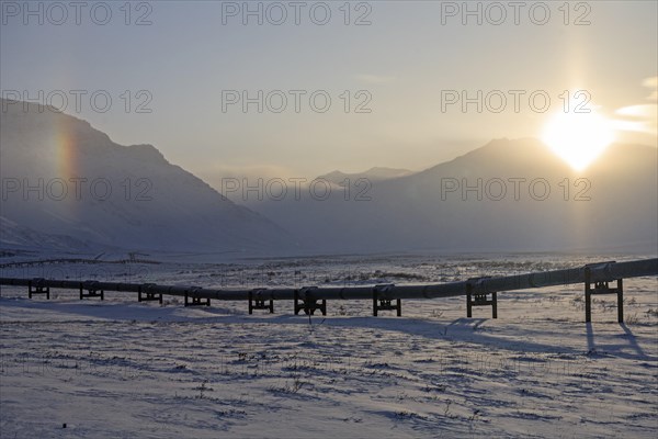 Oil production in the Artkis, Trans-Alaska pipeline backlit, winter, Brooks Range, Alaska, USA,