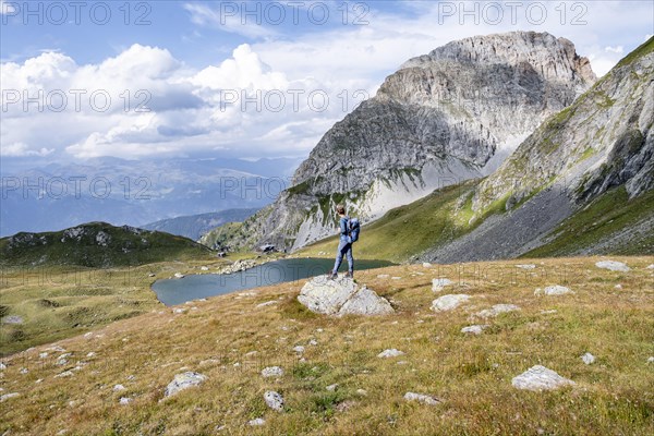 Mountaineer in front of mountain landscape, mountain hut Obstanserseehuette at the mountain lake