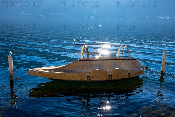 Beautiful Old Fishing Boat on Lake Lugano with Sun Reflection in a Sunny Day in Morcote, Ticino,