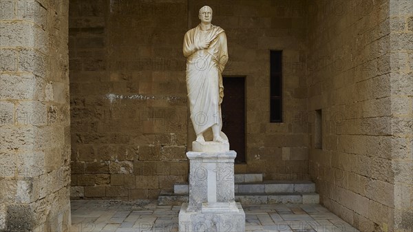 Statue of a man in traditional garb stands on a pedestal in an alcove, statue from the 1st century