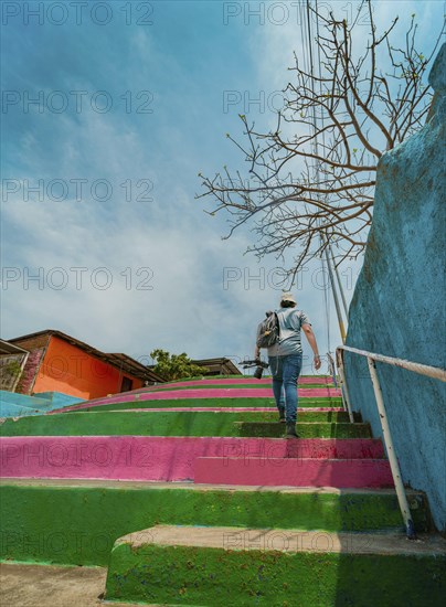 Man climbing multicolored steps. Rear view of a person climbing stairs, Nagarote
