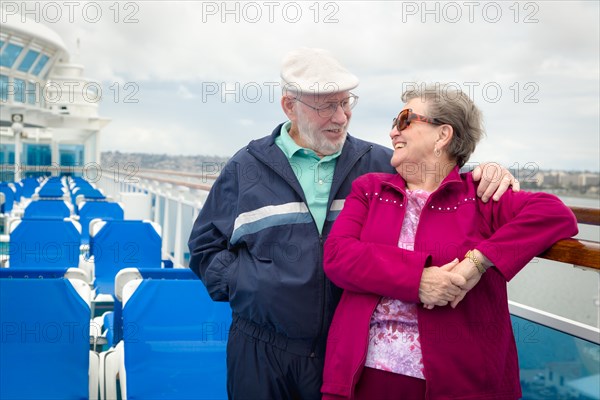 Senior adult couple enjoying the view from their passenger cruise ship railing