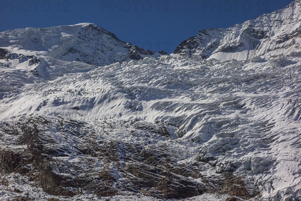Glacier and snow covered mountain with bright blue sky, snow on high mountains in the alps, blue