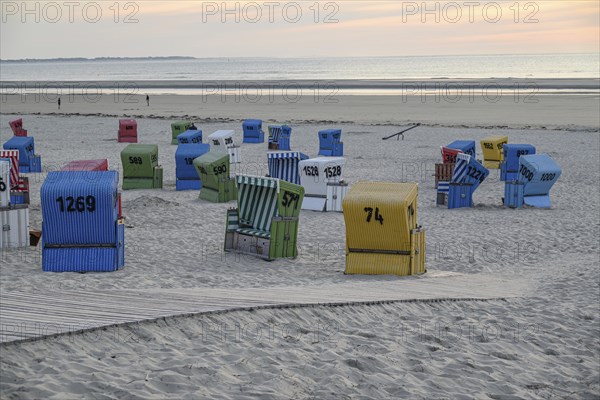 A cool beach evening with colourful beach chairs, a wooden walkway and a quiet atmosphere, lots of