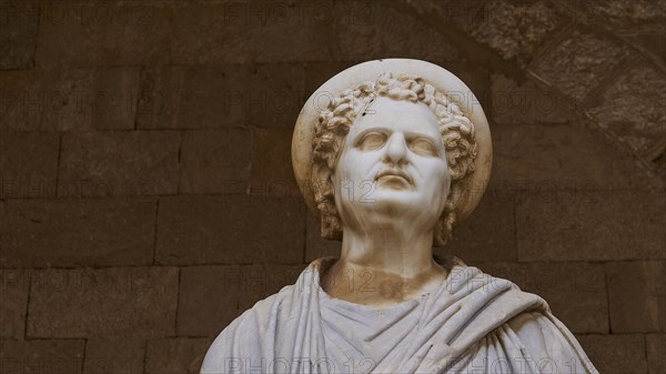Portrait of an ancient statue with curls and lively facial features, Roman statue, courtyard, Grand
