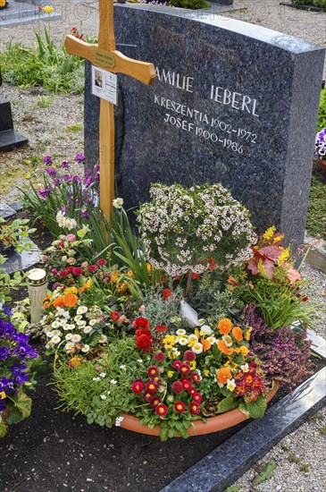 Grave with floral decoration at the cemetery church of St Stephan, Irsee, Swabia, Bavaria, Germany,