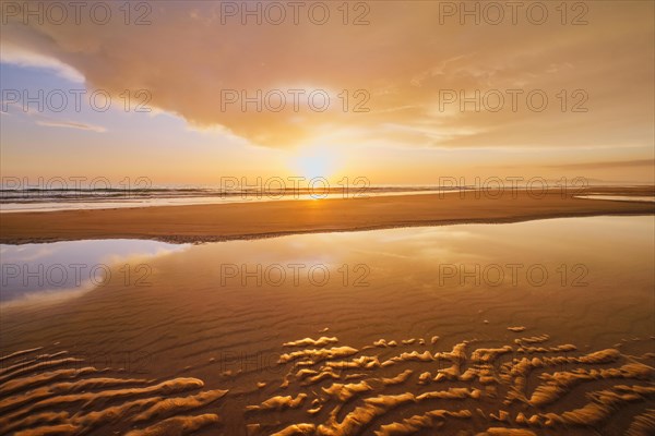 Atlantic ocean sunset with surging waves at Fonte da Telha beach, Costa da Caparica, Portugal,