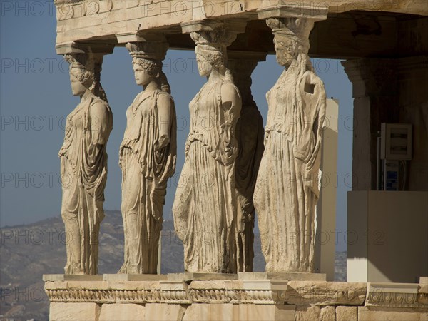 Statues of caryatids replacing columns on the Acropolis, historical columns and ruins on an ancient