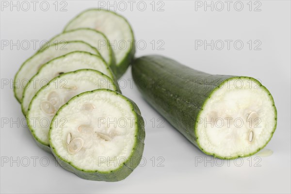 Sponge cucumber or sponge pumpkin (Luffa aegyptiaca, Luffa cylindrica), sliced fruit on a white