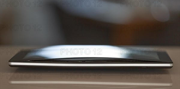A defective, swollen battery pushes the housing of a tablet apart, damaging the display