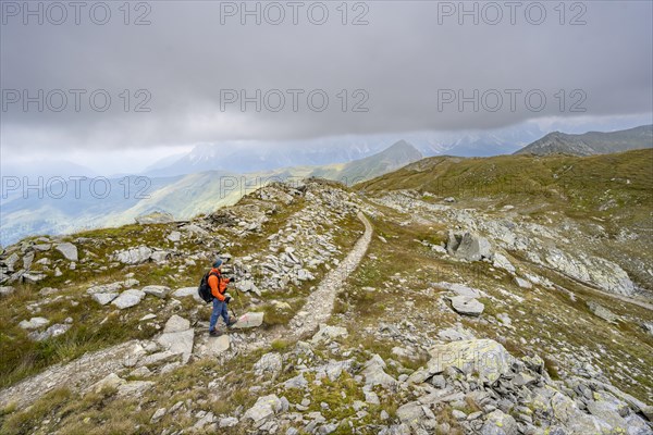 Mountaineers on a hiking trail descending to the Obstanserseehuette, Carnic Main Ridge, Carnic High