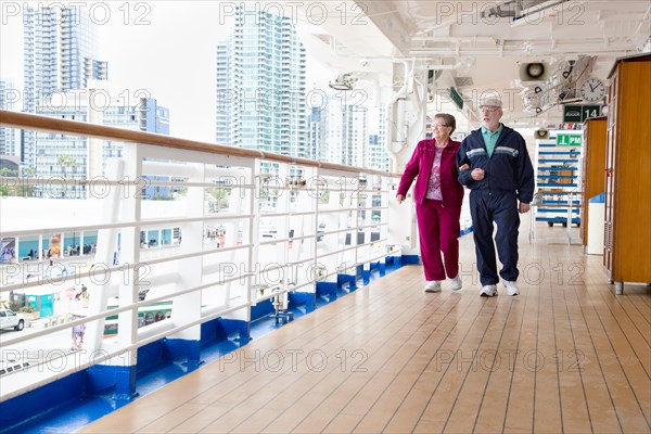 Happy senior couple walking the deck of a luxury passenger cruise ship