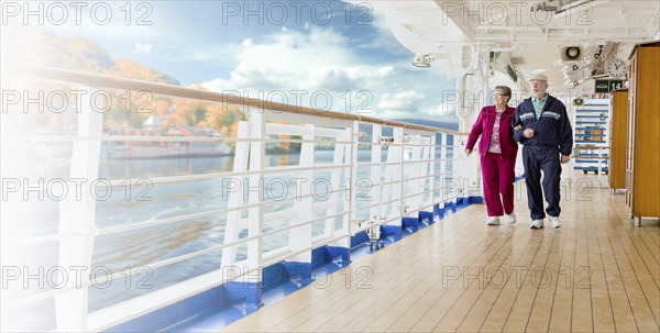 Banner of a happy senior adult couple strolling along the cruise ship deck exercising on a crisp