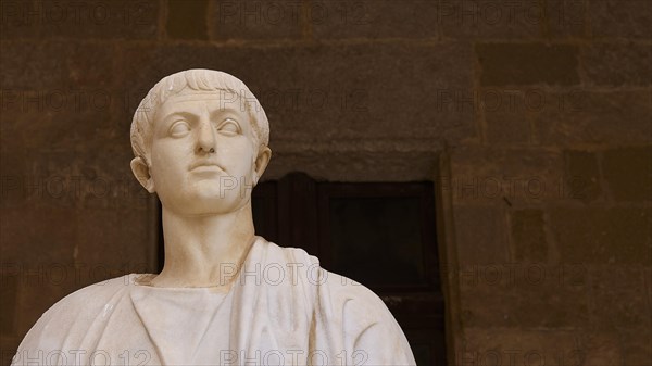Ancient marble statue with distinct facial expression and headdress, statue from the 1st century