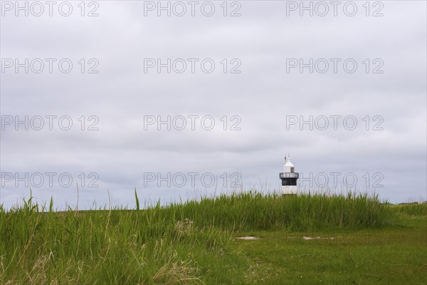 Black and white lighthouse near the North Sea resort Wremen, called 'Kleiner Preusse', behind high