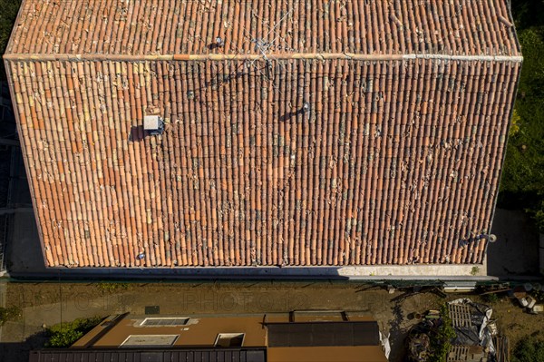 Top down view of a roof with terracotta tiles casting shadows in soft light