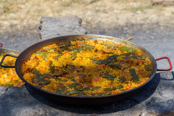 Close-up of a typical Spanish paella cooked over a wood fire in the countryside