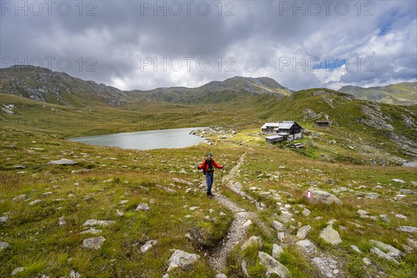 Mountaineer on a hiking trail to the mountain hut Obstanserseehuette at the mountain lake