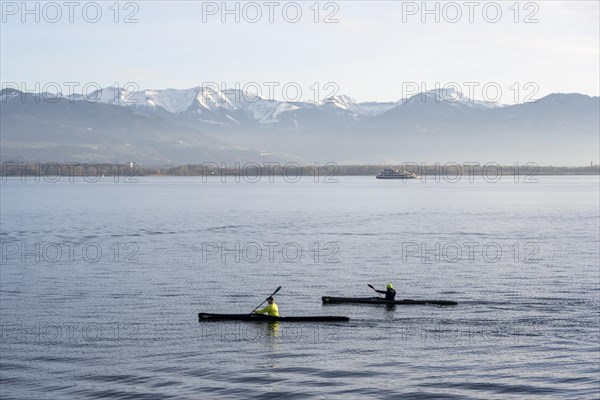 Kayakers paddling in Lake Constance in the evening light, snow-covered mountain peaks, Lindau