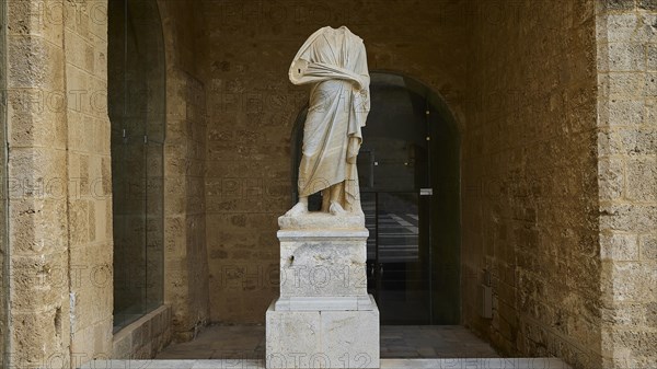 Statue without head and arms on a column in a niche, courtyard, torso of a Roman statue, Grand