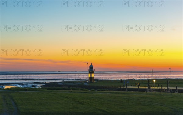 Black and white lighthouse, called 'Kleiner Preusse', stands on the coast of the North Sea under a