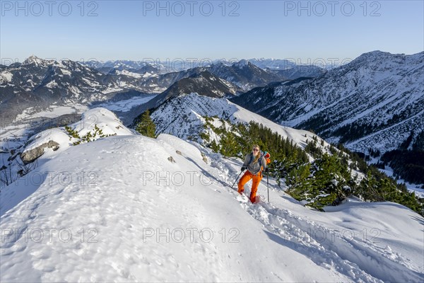 Hiker in winter climbing the Aiplspitz, Mangfall mountains, Bavarian Prealps, Bavaria, Tyrol,