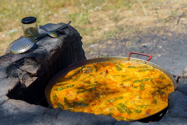 Close-up of a typical Spanish paella cooked over a wood fire in the countryside