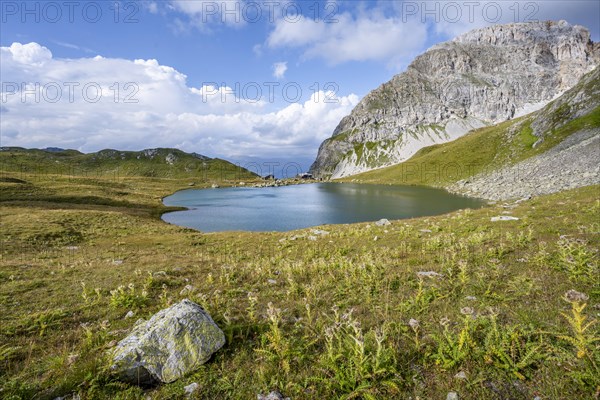 Mountain hut Obstanserseehuette at the mountain lake Obstansersee, behind rocky mountain peak
