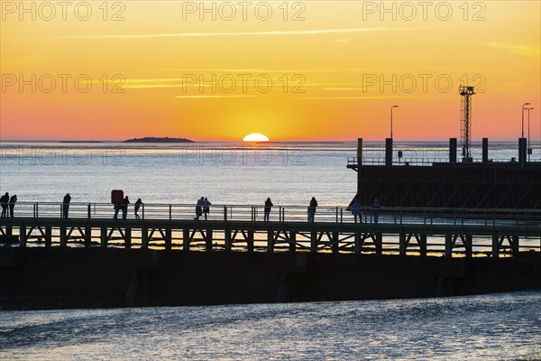 Silhouettes of several people on the pier free canal, jetty, couples and individuals watching the