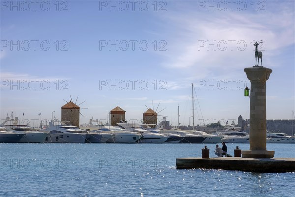 Stag Elafos, sculpture on a column, at the harbour entrance, in the background the three windmills