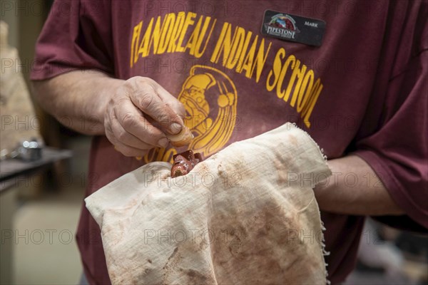 Pipestone, Minnesota, A Native American polishes a pipe he has made from pipestone at Pipestone
