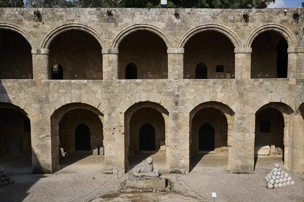 Medieval fortress with symmetrical arcades and lion statue in the courtyard, outdoor area,