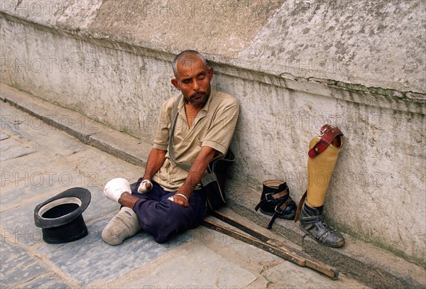 Leper waiting for alms, amputated man with foot and leg prostheses, Kathmandu, Nepal, Asia