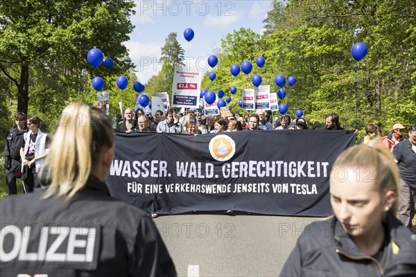 Participants with banner Water. Forest. Justice. For a traffic turnaround beyond Tesla and balloons