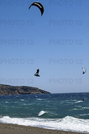 Kitesurfer Kitesurfer takes off in strong wind and waves rough sea moving sea flies with inflated